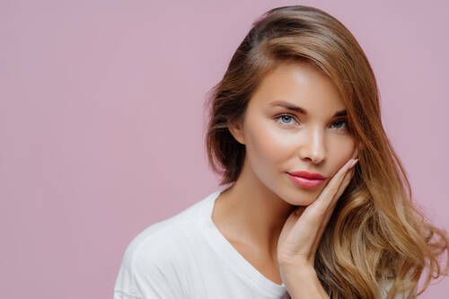 Close up shot self confident beautiful caucasian woman has long hair combed one side