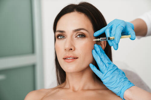 Portrait beautiful woman getting mesotherapy treatment face by specialist gloves beauty salon